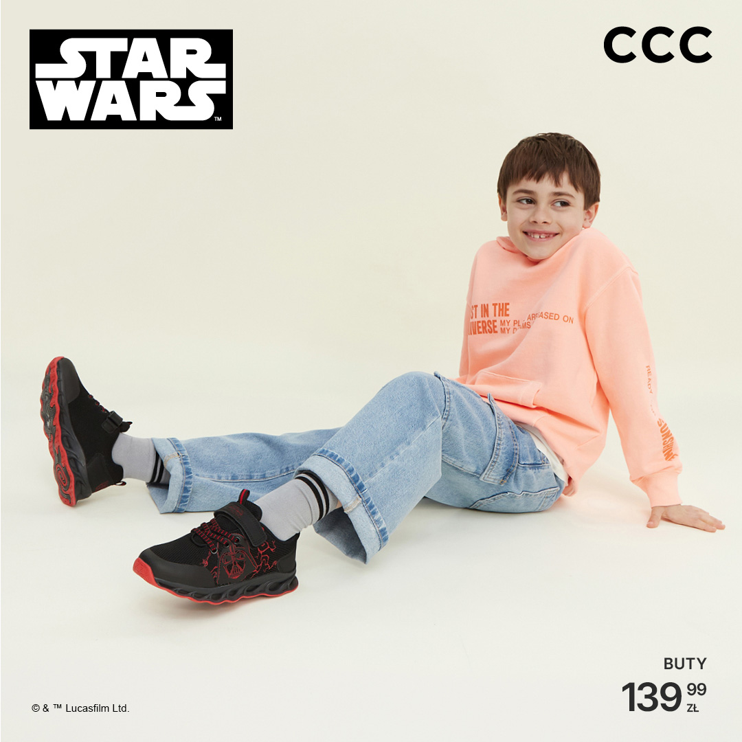 Chłopiec w bluzie i dżinsach noszący buty Star Wars