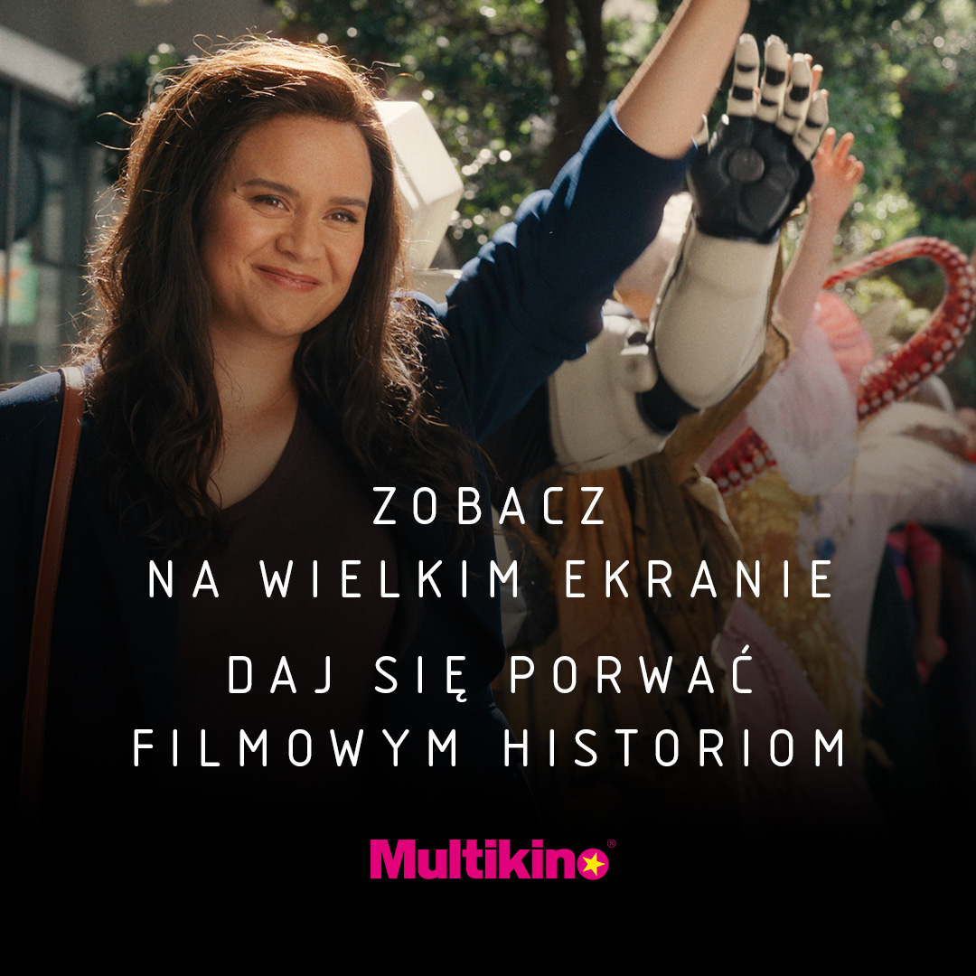 Kobieta uśmiecha się, stojąc przed kinem Multikino.