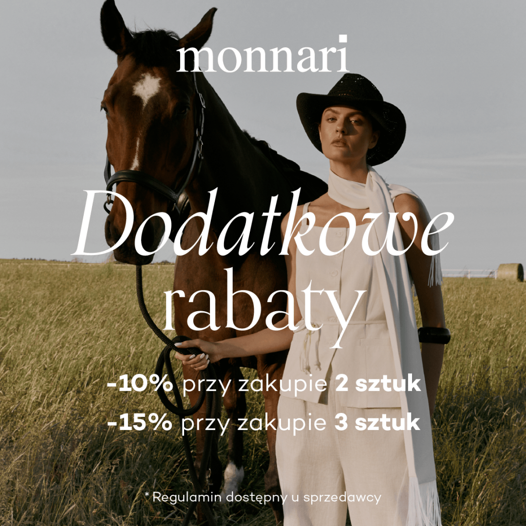 Kobieta w białej sukni stoi obok konia na polu.