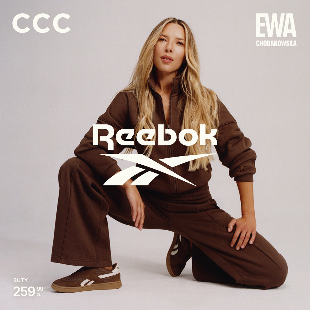Kobieta w brązowym stroju z butami Reebok na białym tle.