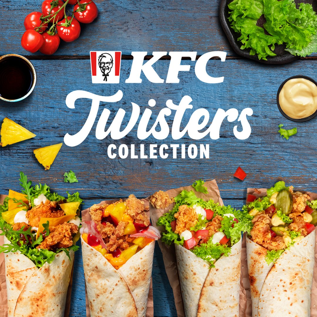 Cztery wrapy KFC Twister z kurczakiem i warzywami na drewnianym stole.